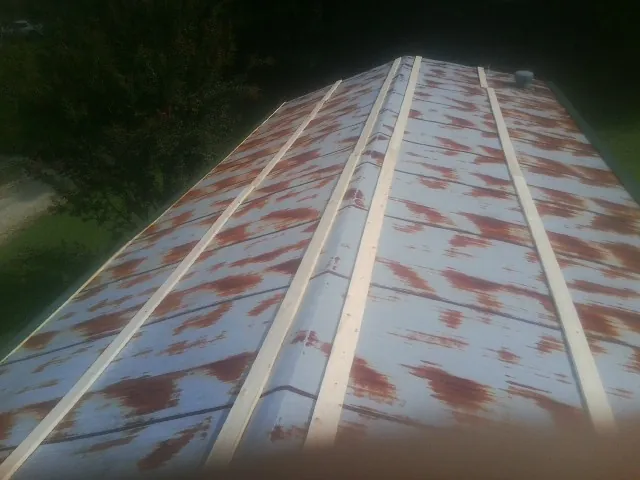 Rusted metal roof panels with new wood purlins before replacement — Storm Damage Roof Repair in Simpson by Roofing Brothers