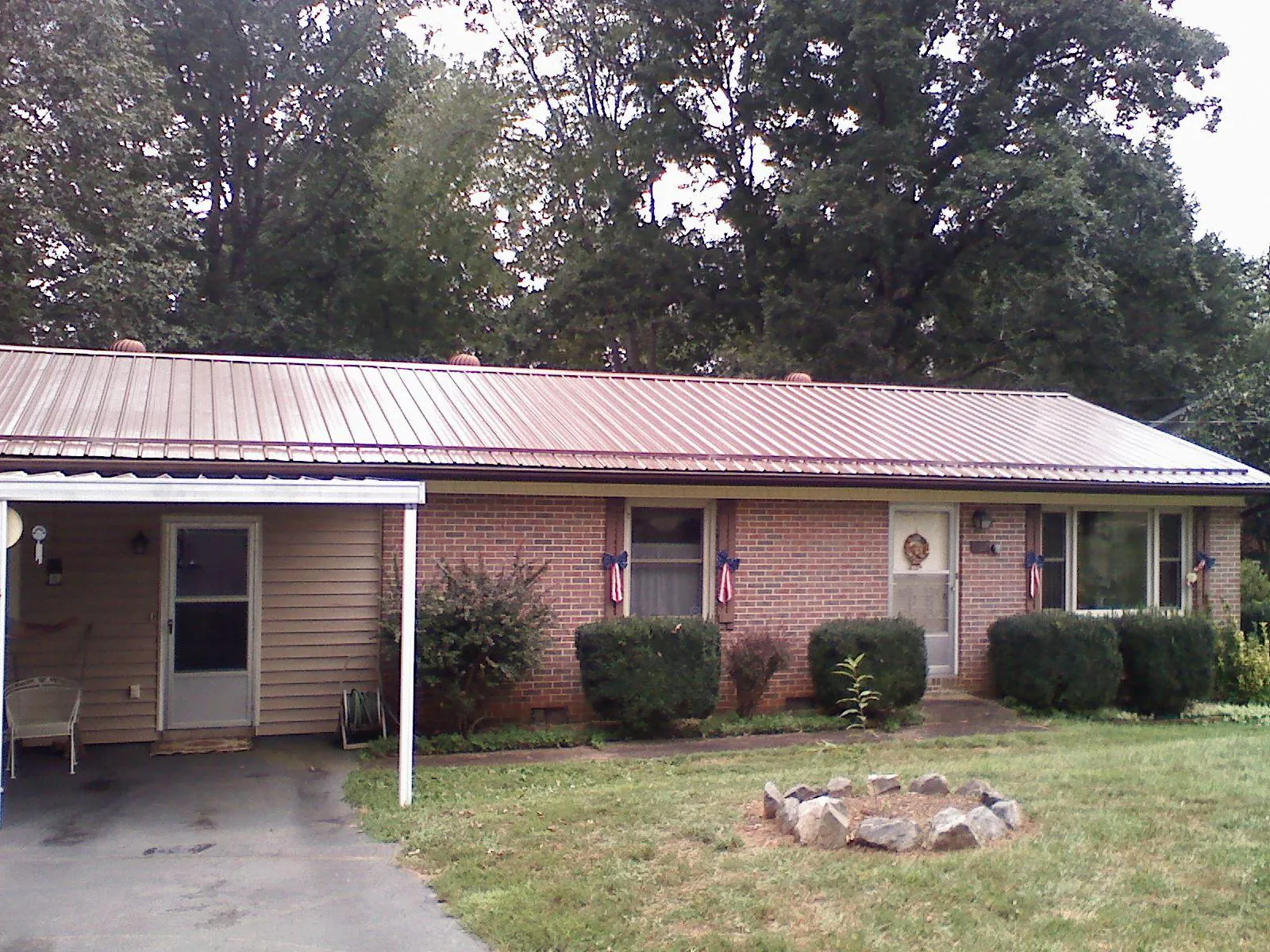 Bronze metal roof and carport on a brick ranch home — Roof Repair work by our crew in Simpson